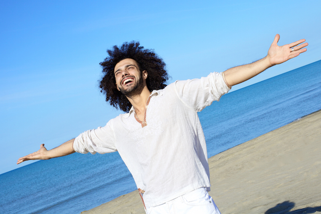Happy handsome man smiling on the beach